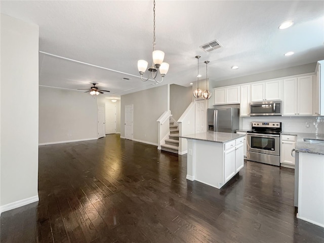 kitchen with stainless steel appliances, dark wood-type flooring, pendant lighting, a center island, and white cabinetry