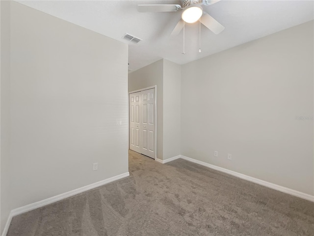 empty room featuring ceiling fan and light colored carpet