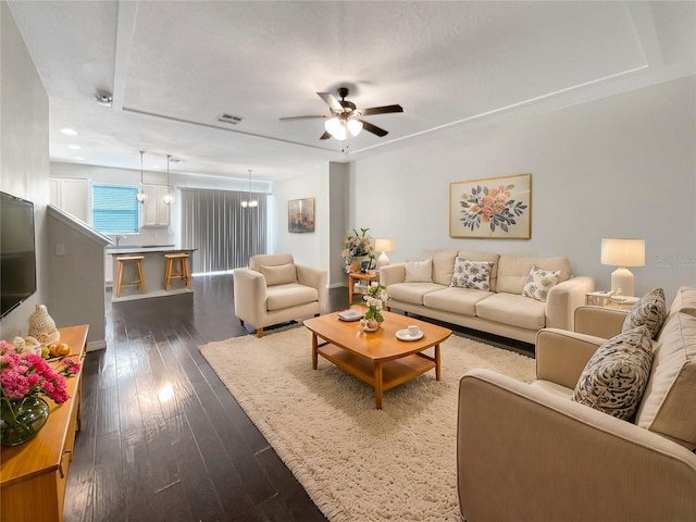 living room with ceiling fan and dark hardwood / wood-style flooring