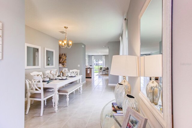 tiled dining room with a notable chandelier