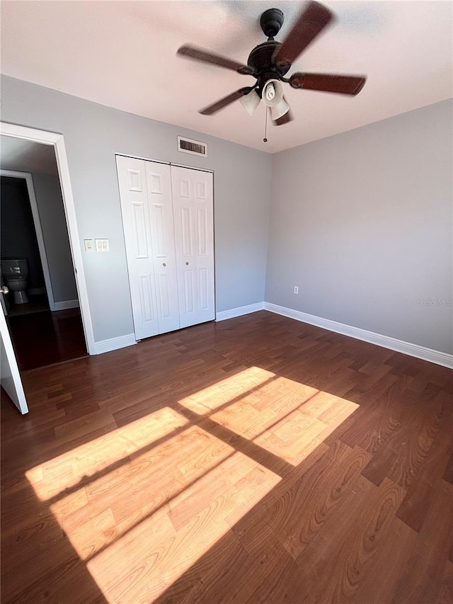 unfurnished bedroom with hardwood / wood-style flooring, ceiling fan, and a closet