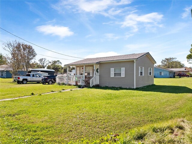 710 Spruce St, New Smyrna Beach, FL 32168 - view of front of property featuring a porch and a front lawn
