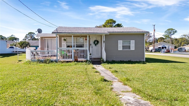 710 Spruce St, New Smyrna Beach, FL 32168 - bungalow-style house with covered porch and a front yard