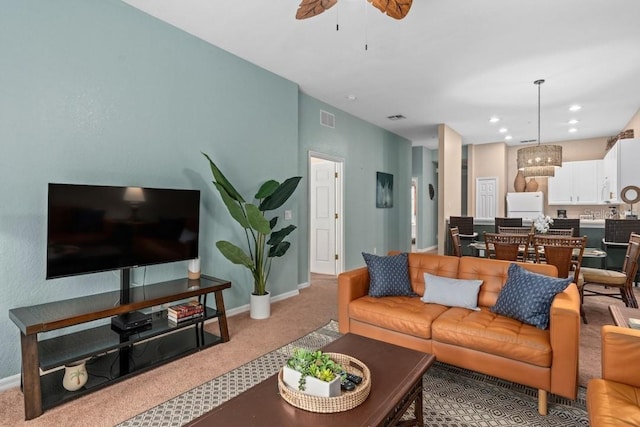 carpeted living room with ceiling fan