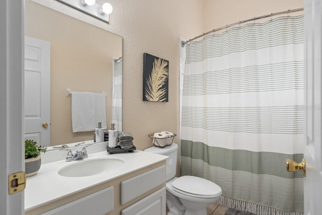 bathroom featuring walk in shower, vanity, and toilet