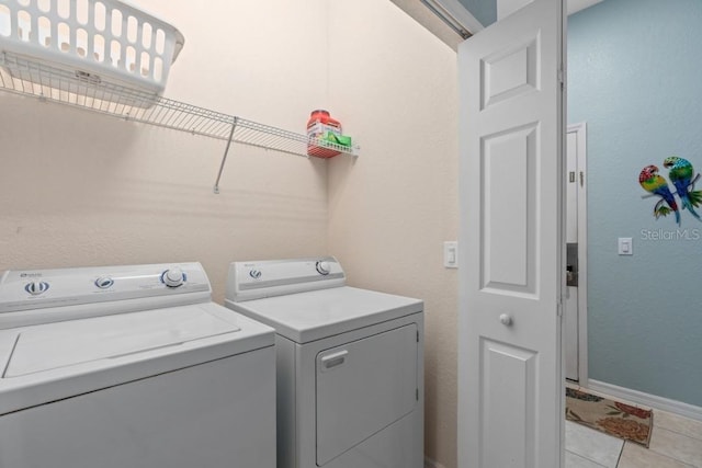 washroom featuring washer and clothes dryer and light tile patterned flooring