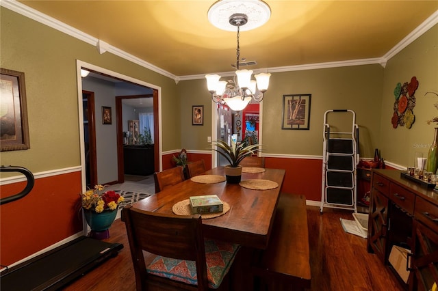 dining room with dark hardwood / wood-style floors, crown molding, and an inviting chandelier