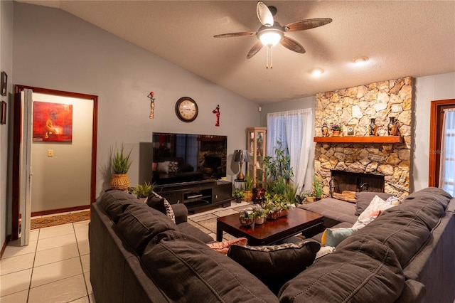 living room featuring lofted ceiling, a stone fireplace, ceiling fan, light tile patterned floors, and a textured ceiling