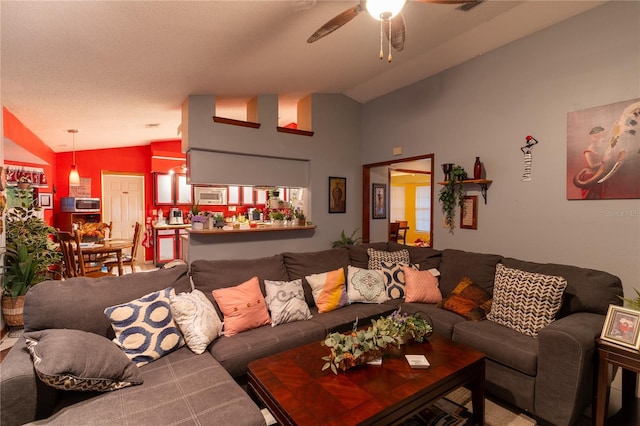 living room featuring a textured ceiling, ceiling fan, and lofted ceiling