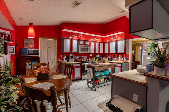 tiled dining room with bar, a textured ceiling, and high vaulted ceiling