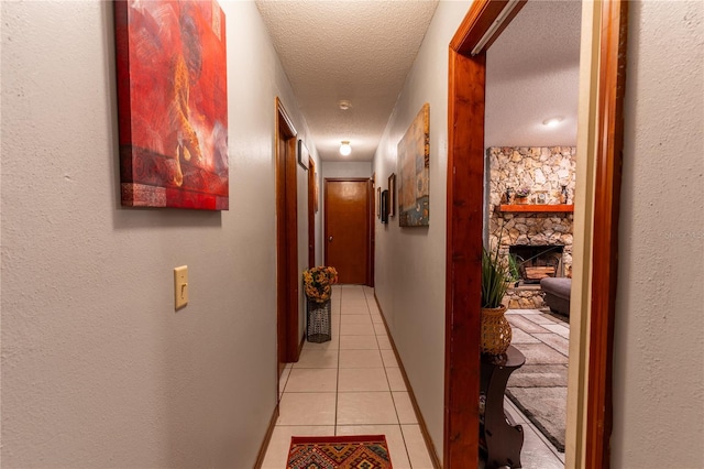 hallway featuring light tile patterned floors and a textured ceiling