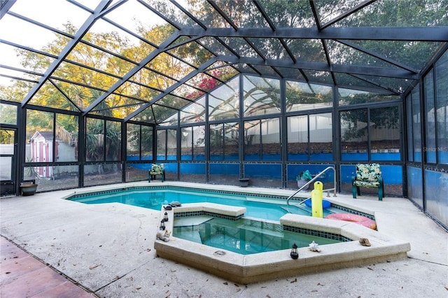 view of swimming pool with glass enclosure, a storage shed, an in ground hot tub, and a patio