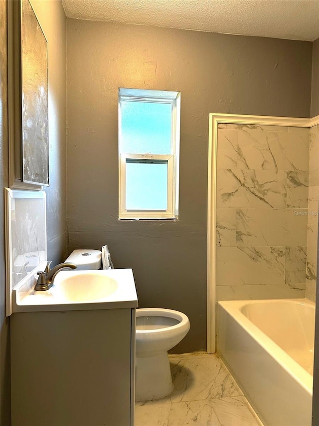 bathroom with a textured ceiling, vanity, and toilet