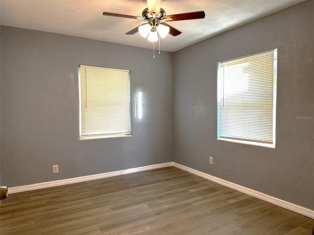 empty room with hardwood / wood-style flooring, ceiling fan, and a textured ceiling