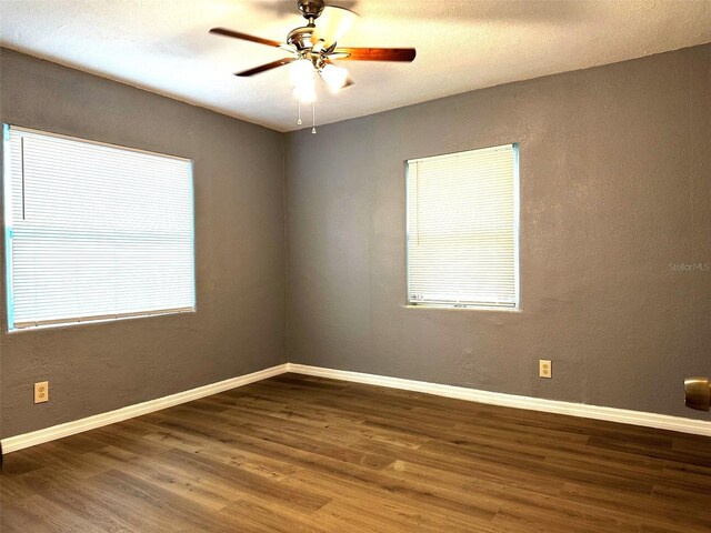 spare room featuring dark hardwood / wood-style floors, a healthy amount of sunlight, and ceiling fan