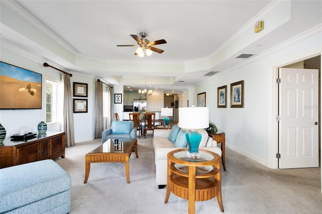 living room with a raised ceiling, crown molding, light colored carpet, and ceiling fan with notable chandelier