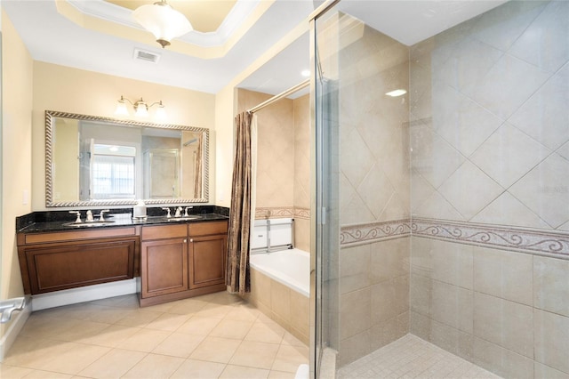 bathroom with shower with separate bathtub, vanity, a tray ceiling, and tile patterned floors