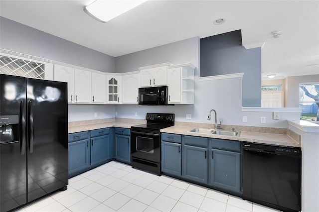 kitchen featuring black appliances, sink, blue cabinetry, light tile patterned flooring, and white cabinetry