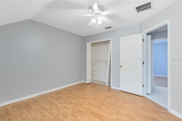 unfurnished bedroom featuring a closet, ceiling fan, light hardwood / wood-style flooring, and vaulted ceiling