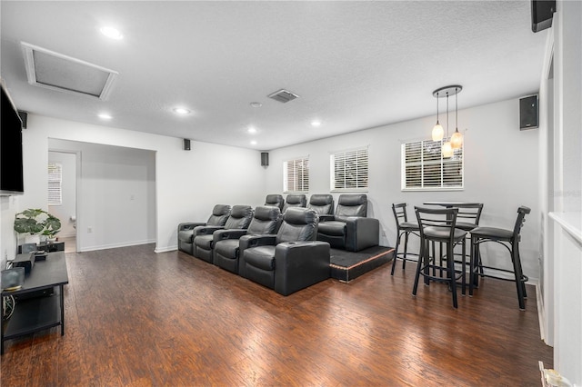 cinema with dark hardwood / wood-style floors and a textured ceiling