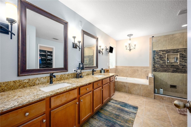 bathroom featuring tile patterned floors, a textured ceiling, vanity, independent shower and bath, and a notable chandelier