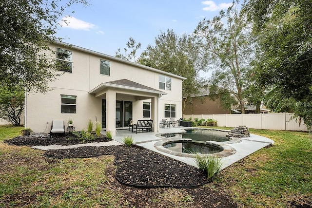 rear view of house with a pool with hot tub, a lawn, and a patio