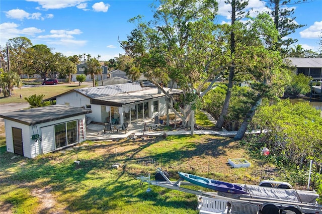 back of property with a yard and a patio