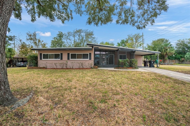 single story home featuring a front lawn and a carport