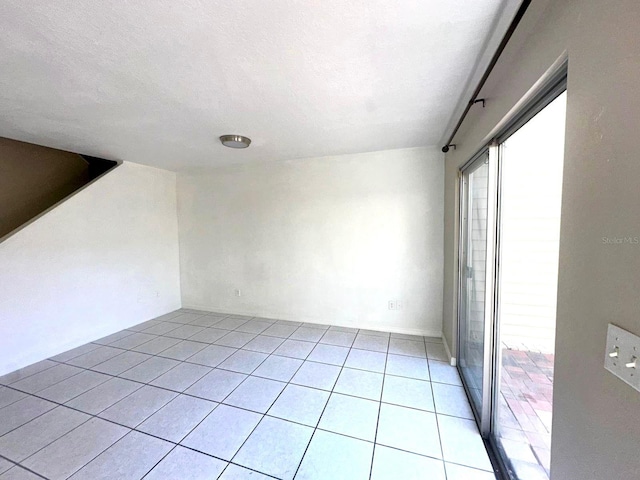 tiled empty room with a textured ceiling