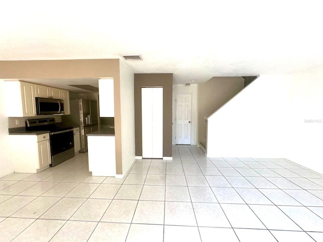 kitchen with light tile patterned flooring and appliances with stainless steel finishes