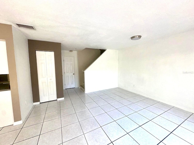 tiled empty room with a textured ceiling