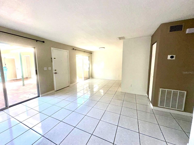 spare room featuring a textured ceiling and light tile patterned flooring