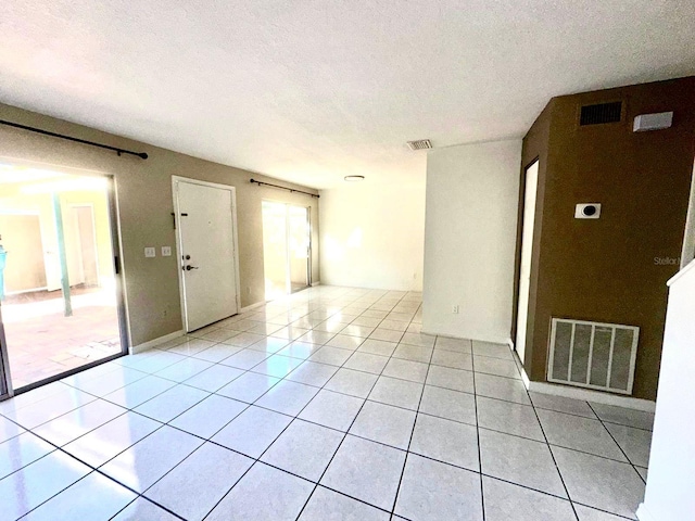 tiled spare room with a textured ceiling