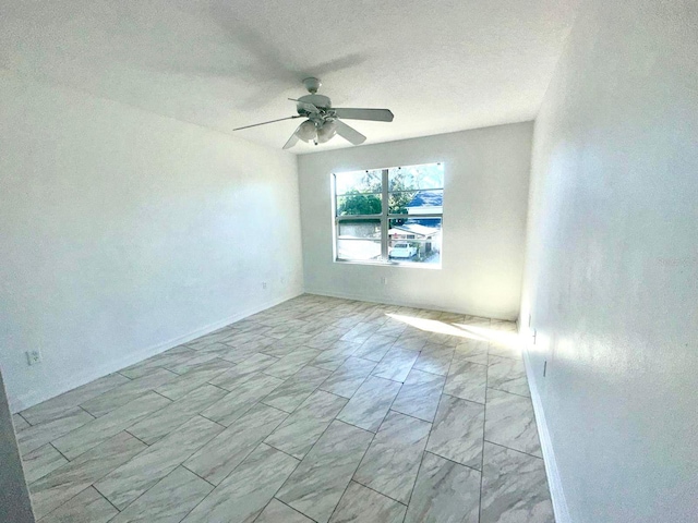 empty room featuring ceiling fan and a textured ceiling