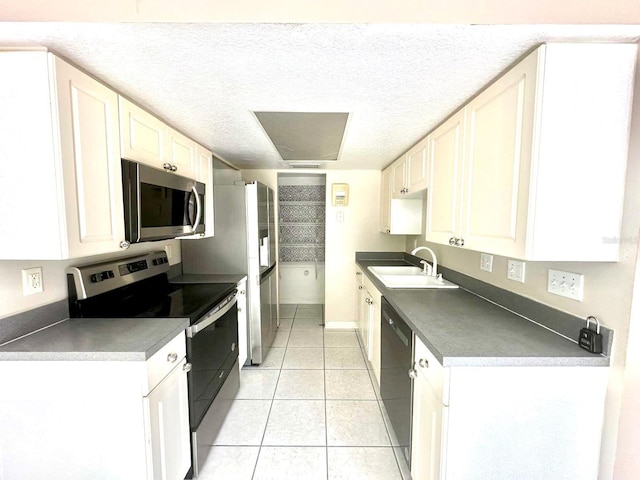 kitchen featuring white cabinetry, sink, a textured ceiling, light tile patterned floors, and appliances with stainless steel finishes