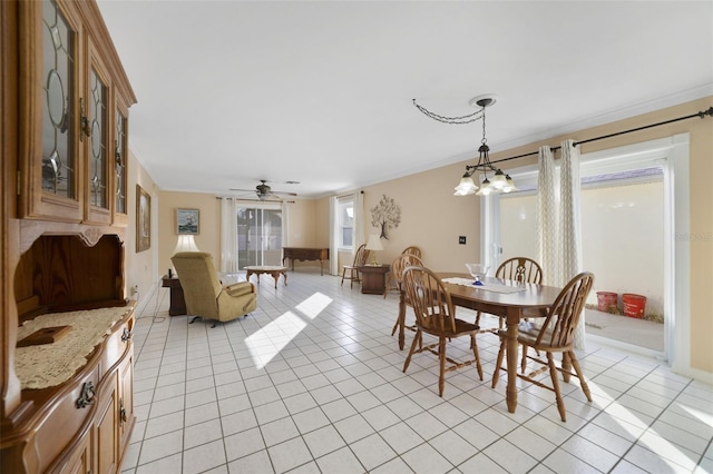 dining space with light tile patterned floors, ceiling fan with notable chandelier, and ornamental molding