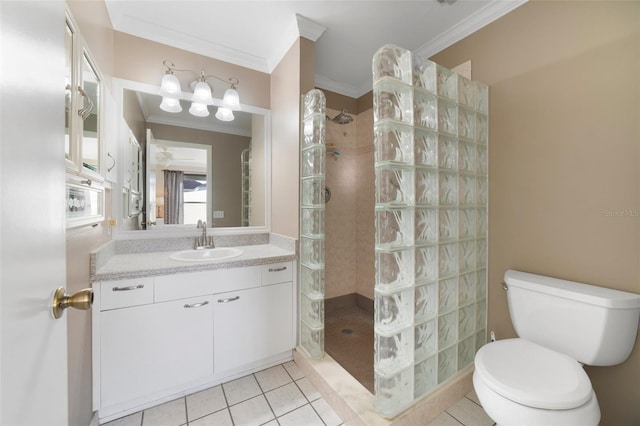 bathroom with vanity, crown molding, tile patterned flooring, toilet, and a tile shower