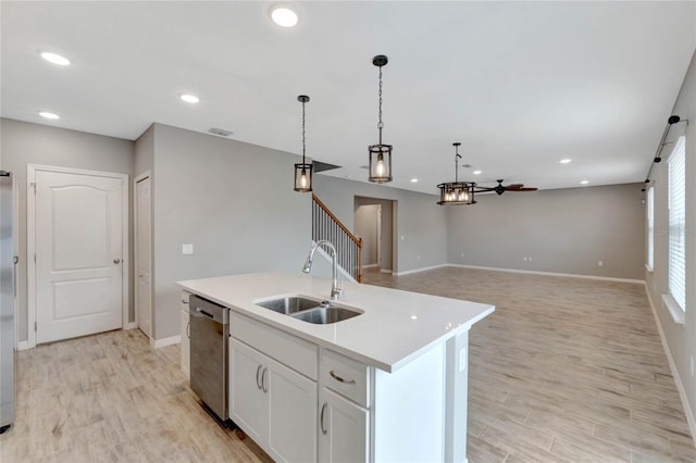 kitchen with stainless steel dishwasher, ceiling fan, a kitchen island with sink, sink, and white cabinetry