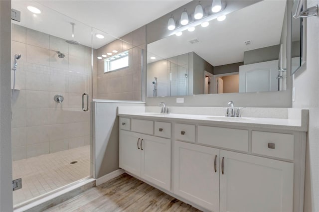 bathroom featuring vanity, wood-type flooring, and walk in shower