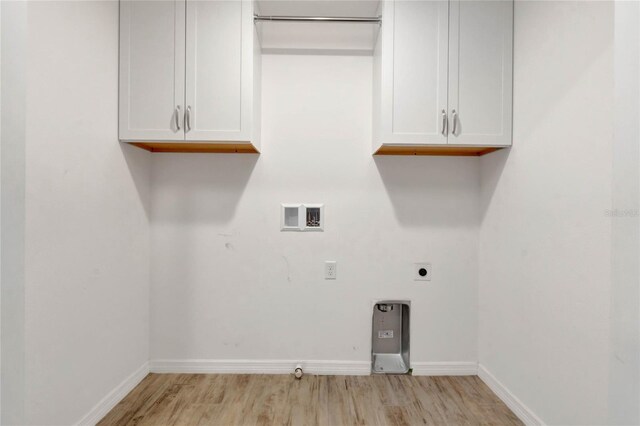 clothes washing area with cabinets, washer hookup, electric dryer hookup, light hardwood / wood-style floors, and hookup for a gas dryer