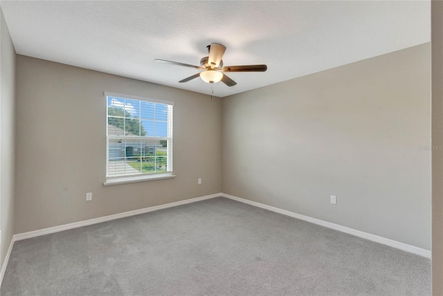 empty room featuring ceiling fan and light carpet