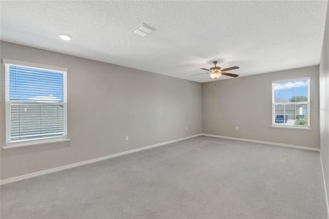 carpeted spare room with ceiling fan and a textured ceiling