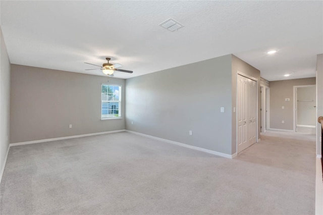 carpeted spare room featuring ceiling fan