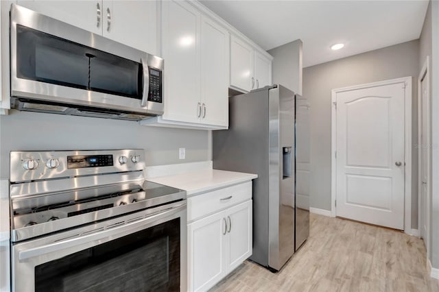 kitchen with white cabinets, light wood-type flooring, and appliances with stainless steel finishes