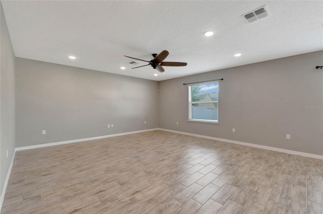 empty room with ceiling fan and a textured ceiling