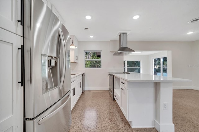 kitchen featuring white cabinets, appliances with stainless steel finishes, kitchen peninsula, and wall chimney exhaust hood