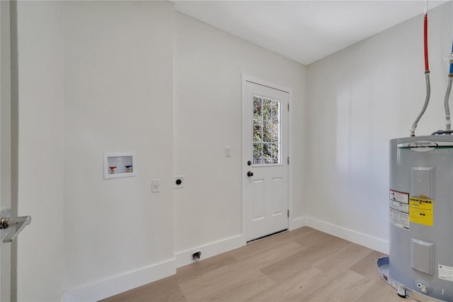 laundry area featuring electric dryer hookup, electric water heater, light hardwood / wood-style floors, and washer hookup