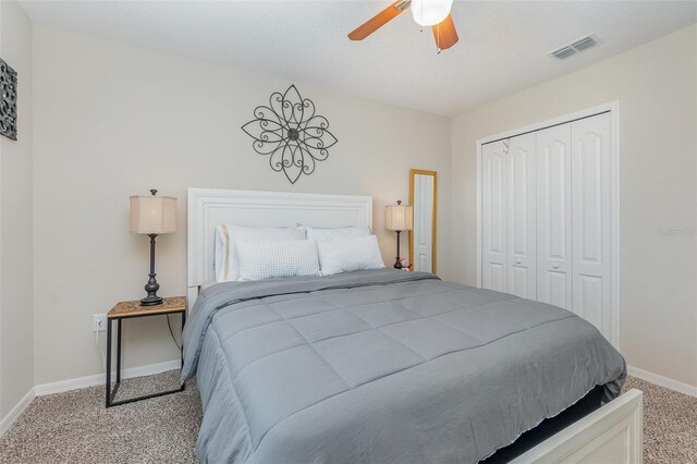 carpeted bedroom featuring ceiling fan and a closet