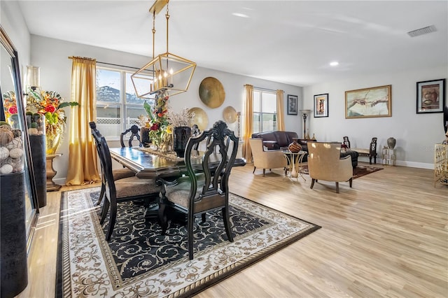 dining area featuring an inviting chandelier, light hardwood / wood-style flooring, and plenty of natural light