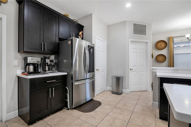 kitchen with light tile patterned floors and stainless steel refrigerator